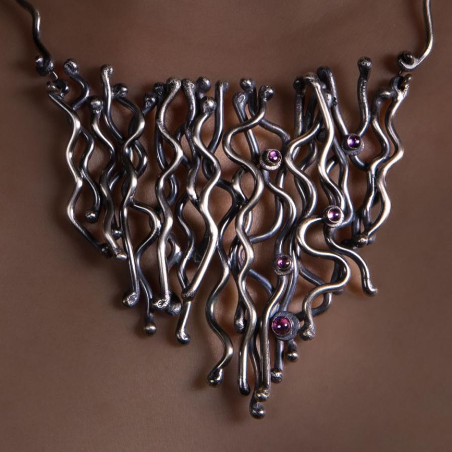 Woman wears silver necklace.