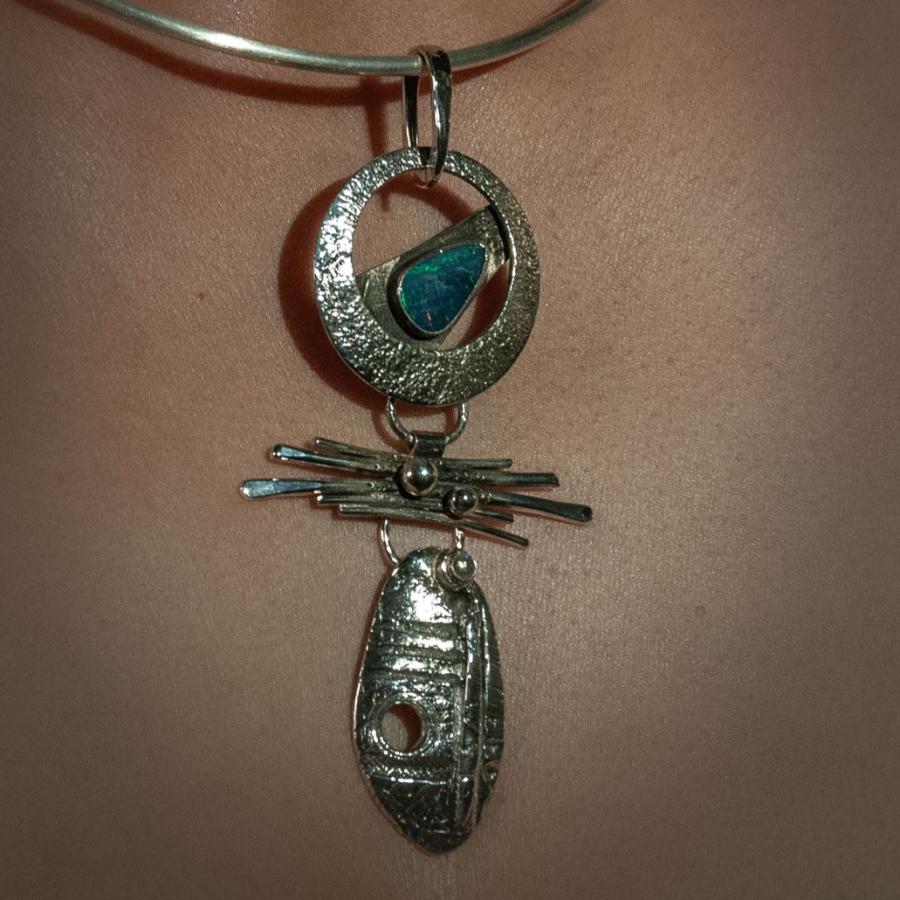 Necklace with silver pendant on a person.