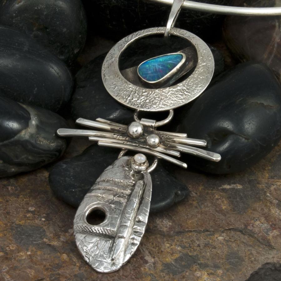 Silver necklace with opal on dark stones, close-up.