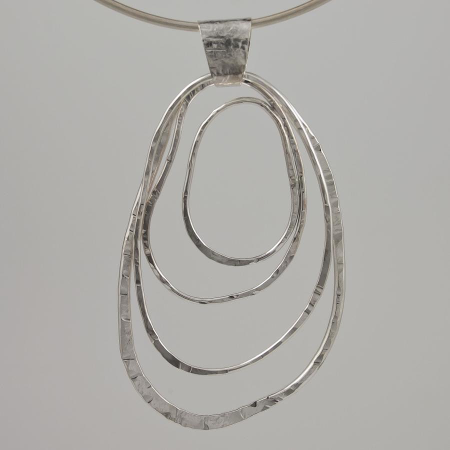 Silver pendant with asymmetrical circle design.
