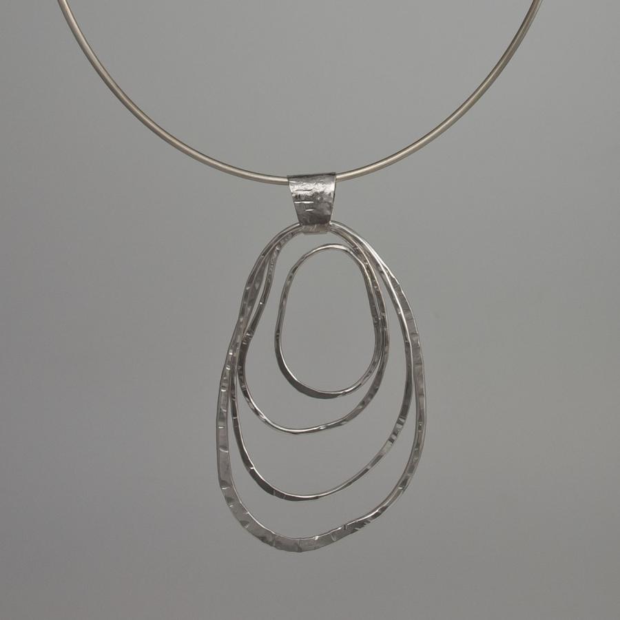 Silver choker necklace with layered pendant, studio photograph.