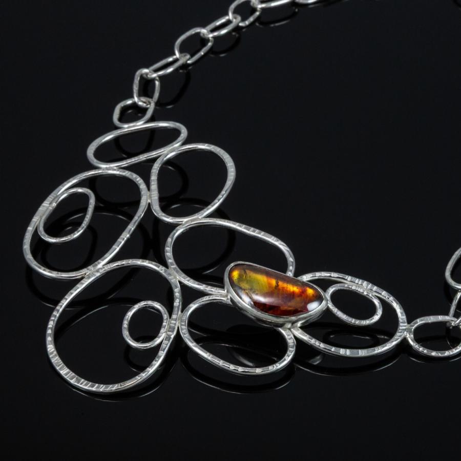 Necklace with silver loops and an amber stone.