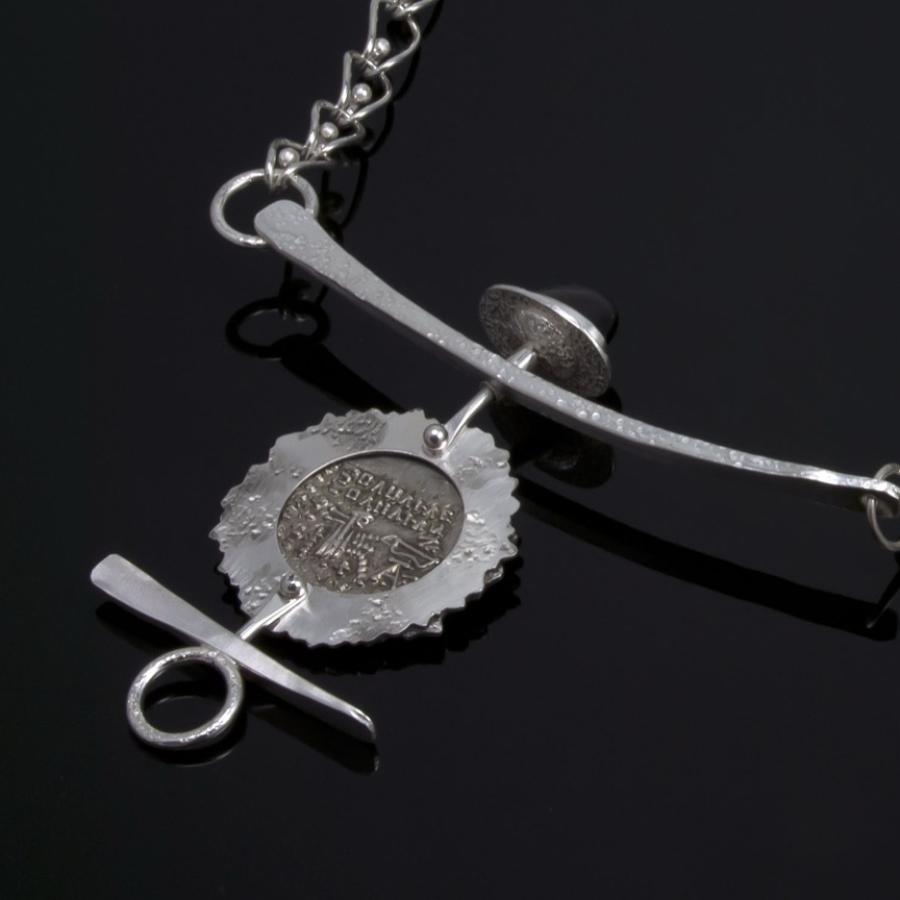 Silver chain necklace with coin pendant.