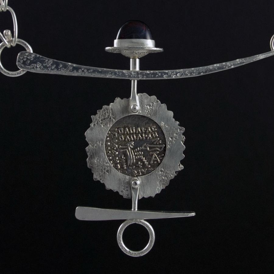 Silver chain necklace with coin pendant.
