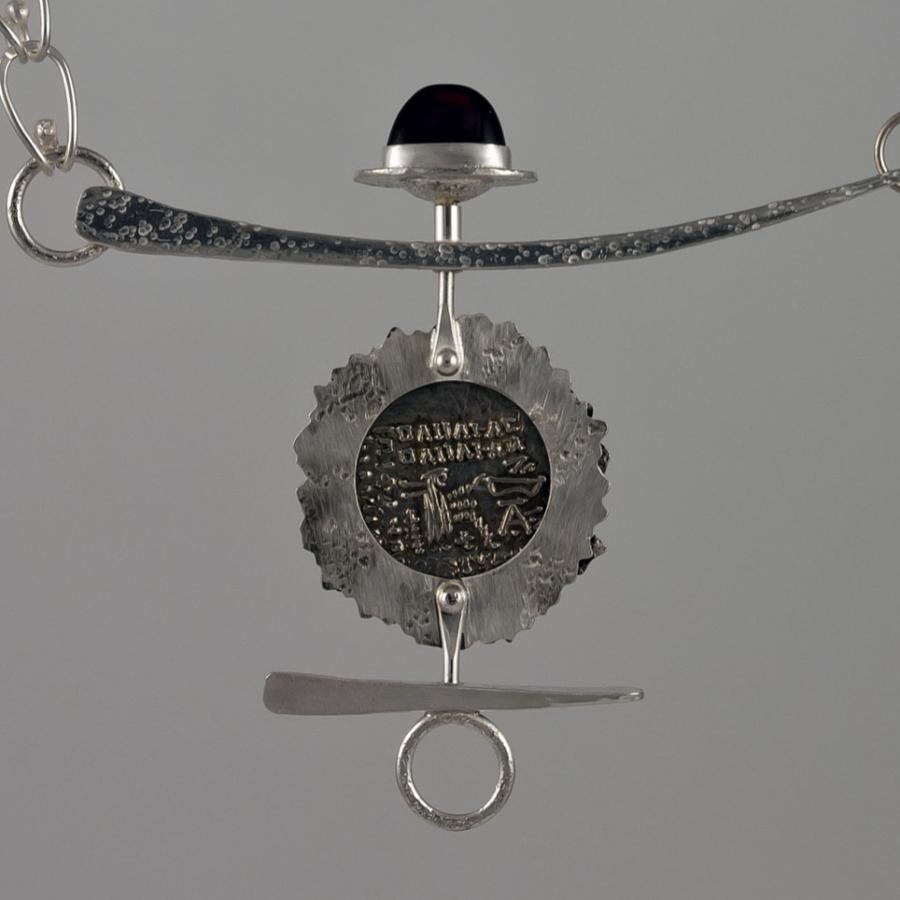 Silver chain necklace with coin pendant.
