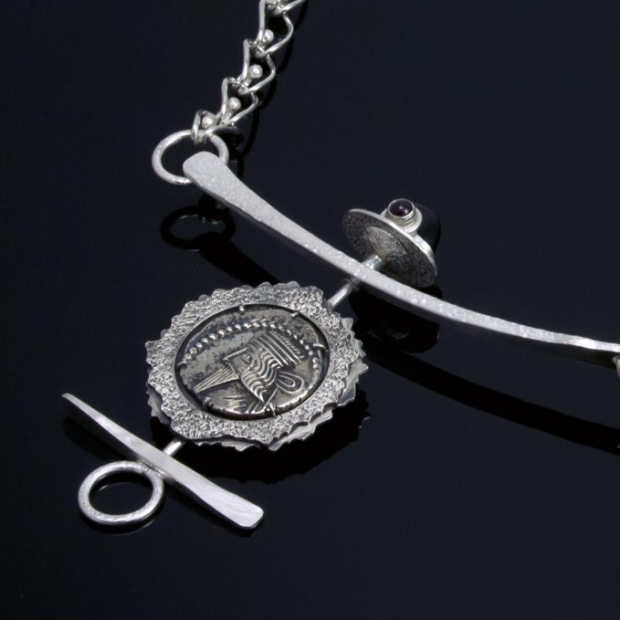 Silver chain necklace with coin pendant.