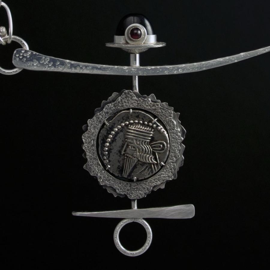 Silver chain necklace with coin pendant.