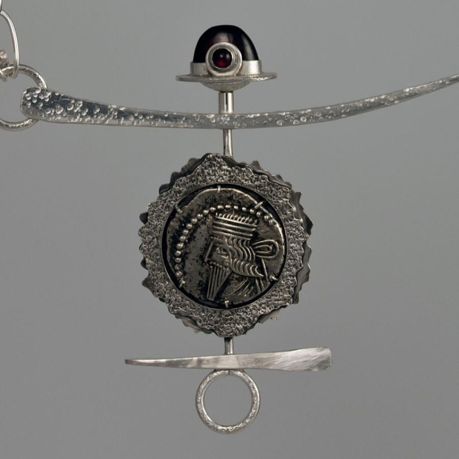 Silver chain necklace with coin pendant.