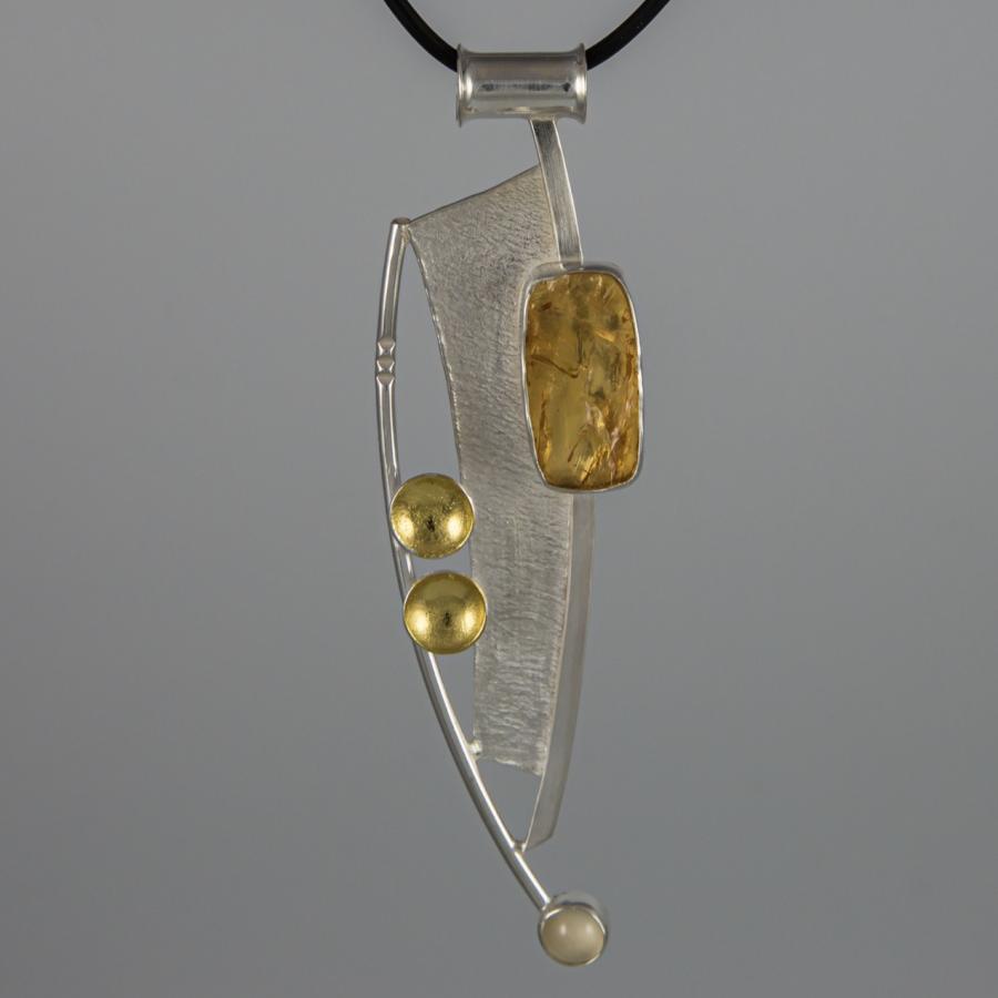 Pendant necklace with silver, gold, and amber-colored accents.