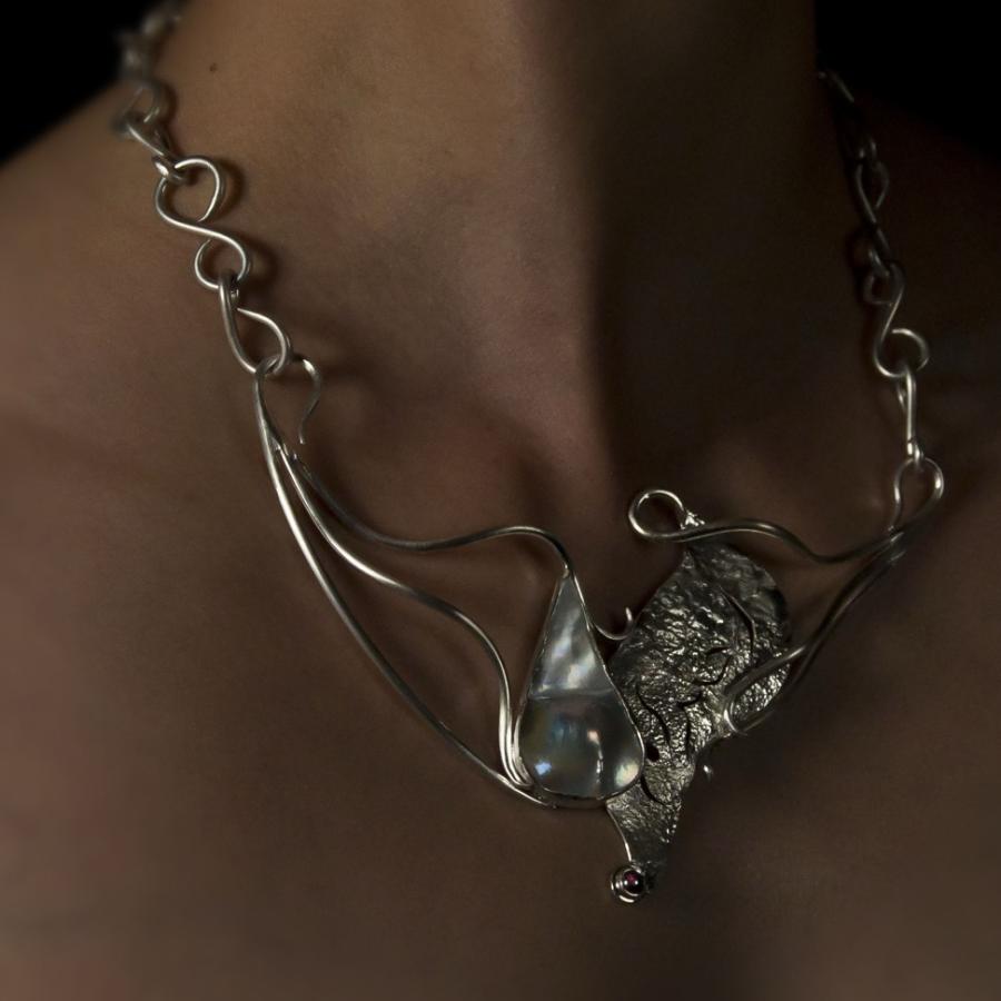 Silver necklace with blister pearl and garnet worn by a model