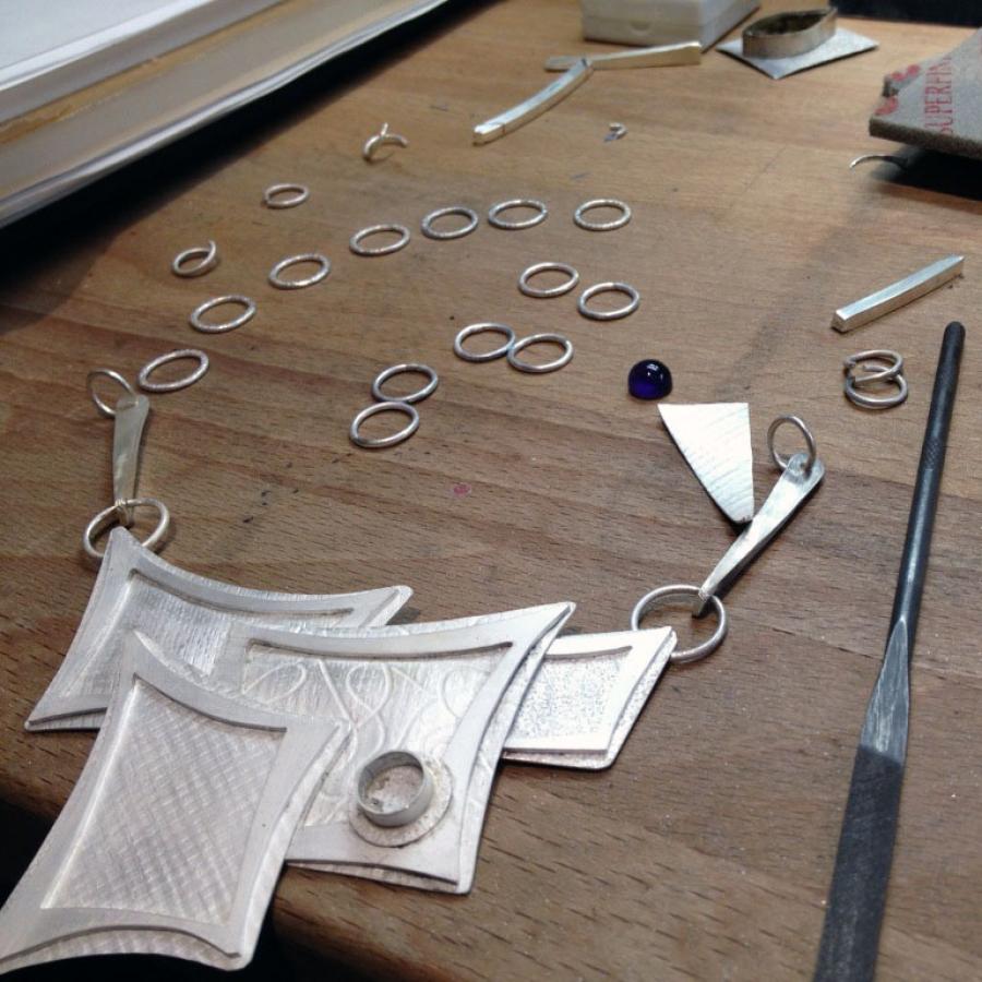 Jewelry and tools on wooden workbench.