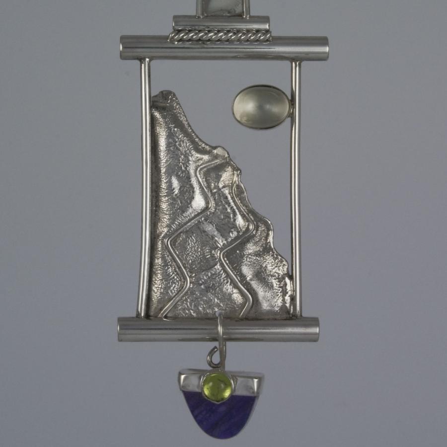 Silver pendant necklace with mountain and moon design.
