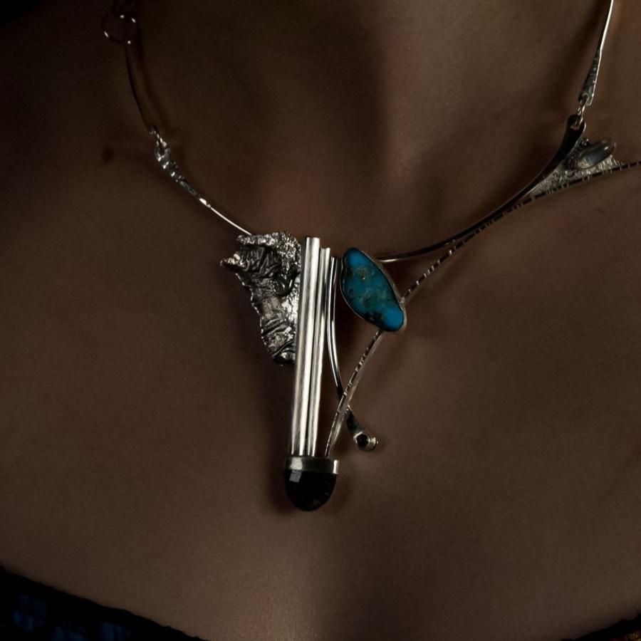 Woman wearing a handcrafted silver and turquoise necklace.