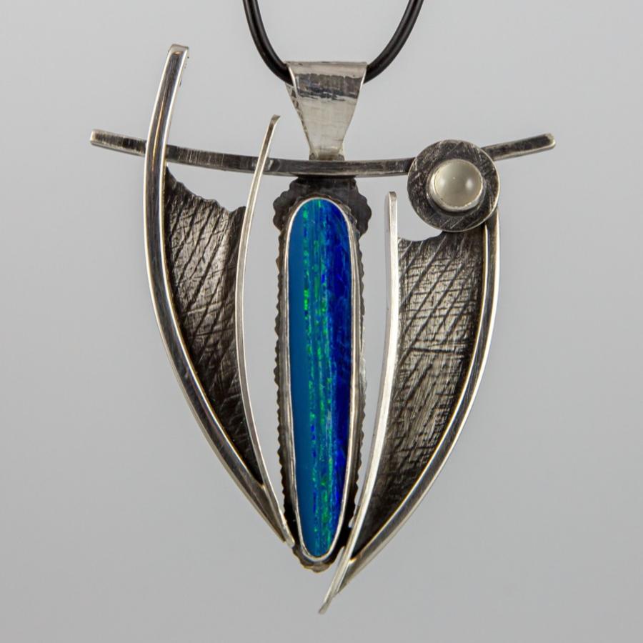 Silver pendant with opal on black cord.