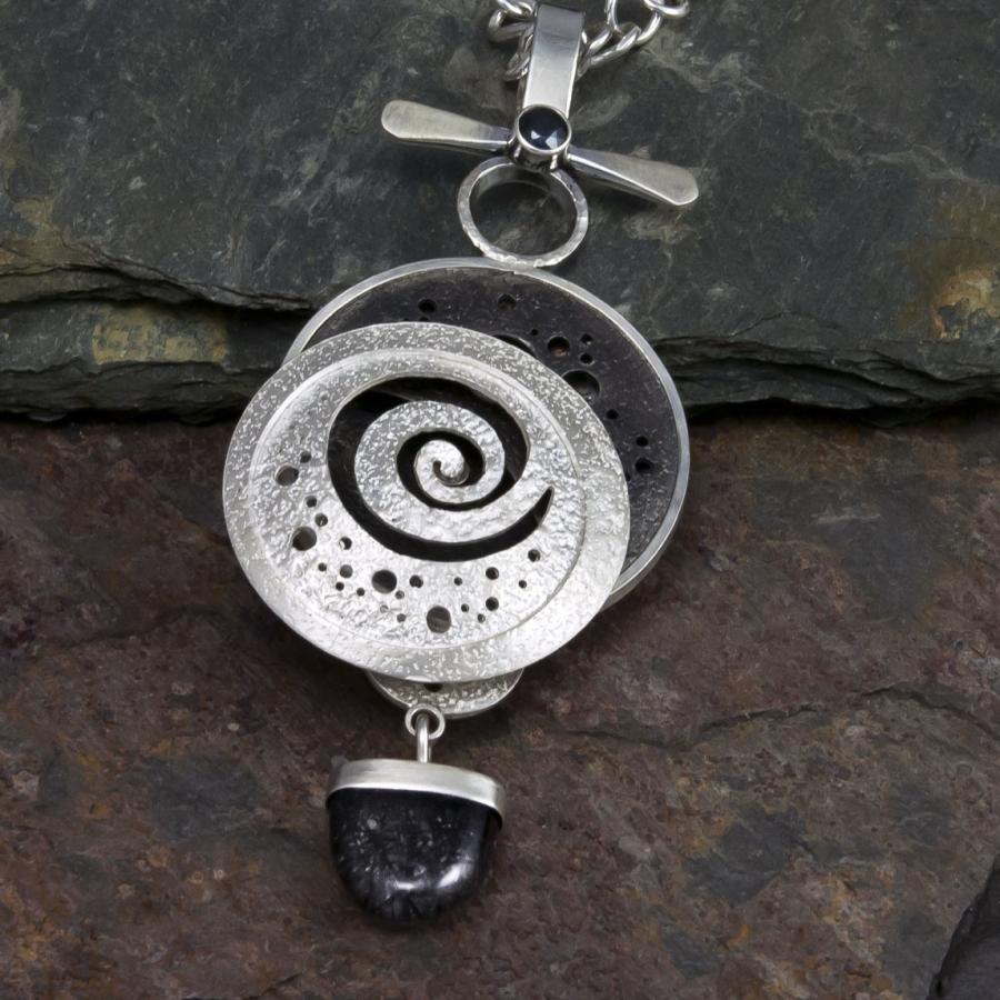 Silver necklace featuring a spiral design pendant.