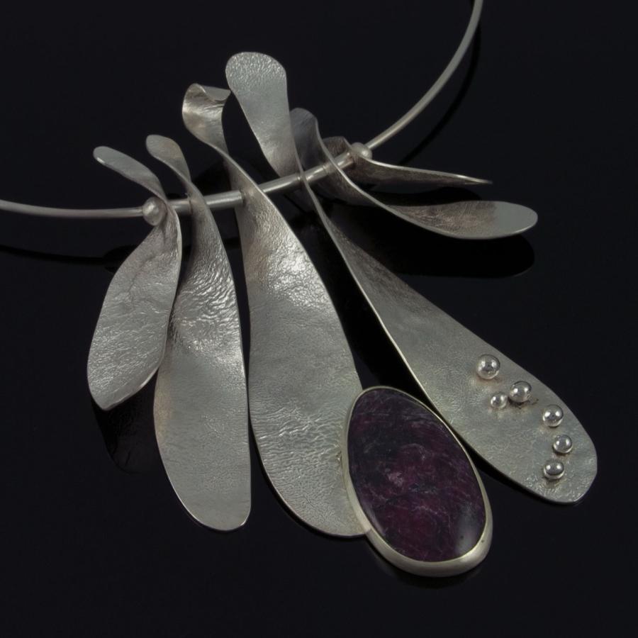 Silver pendant necklace with purple stone, jewelry photograph.