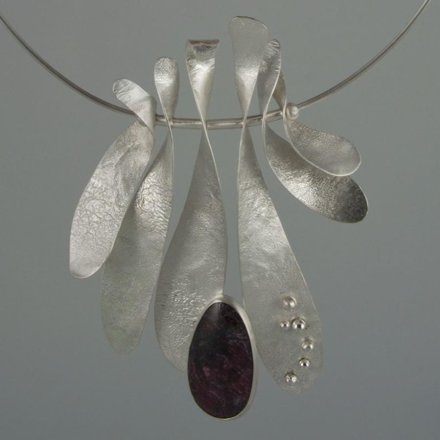 Silver necklace with leaf-shaped pendants and purple gemstone.