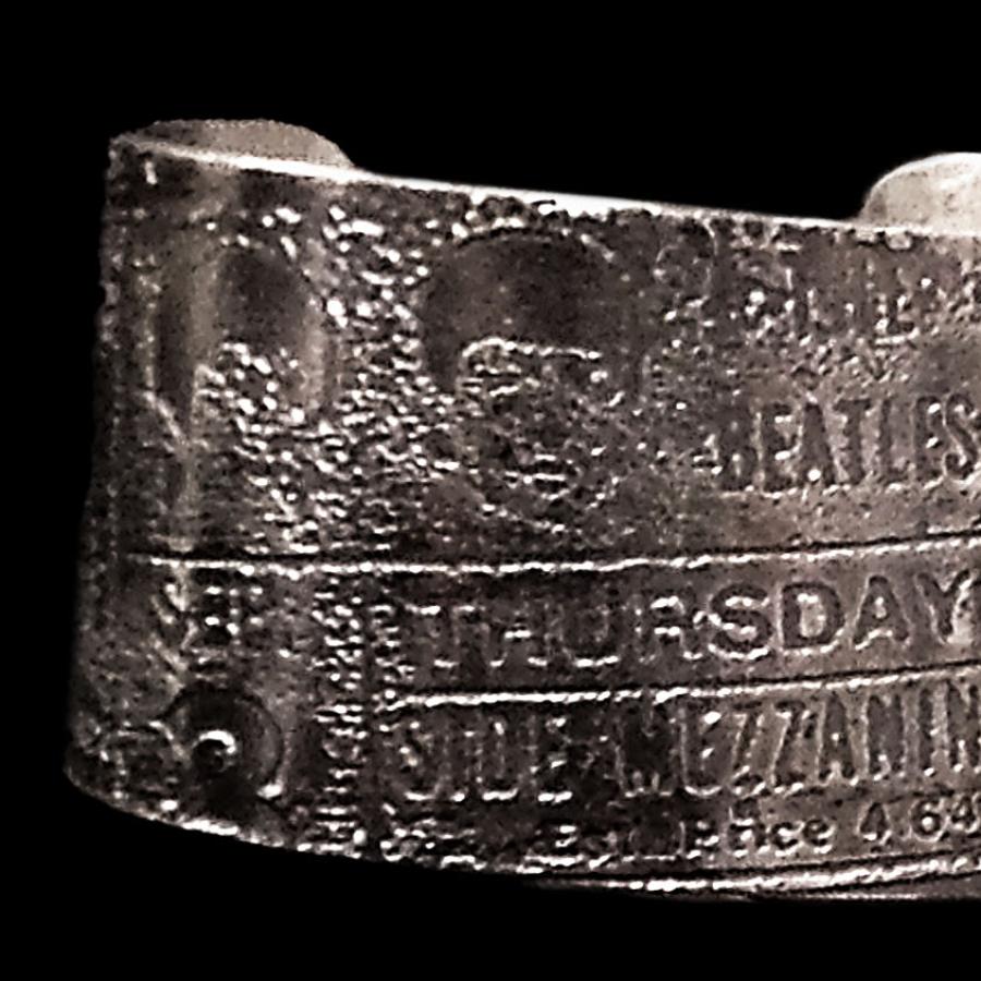 Wide silver bracelet on rocks, close-up.