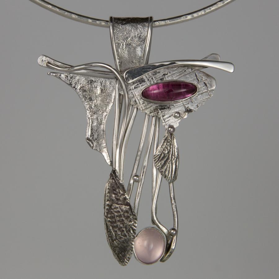 Silver pendant necklace with pink and purple stones.
