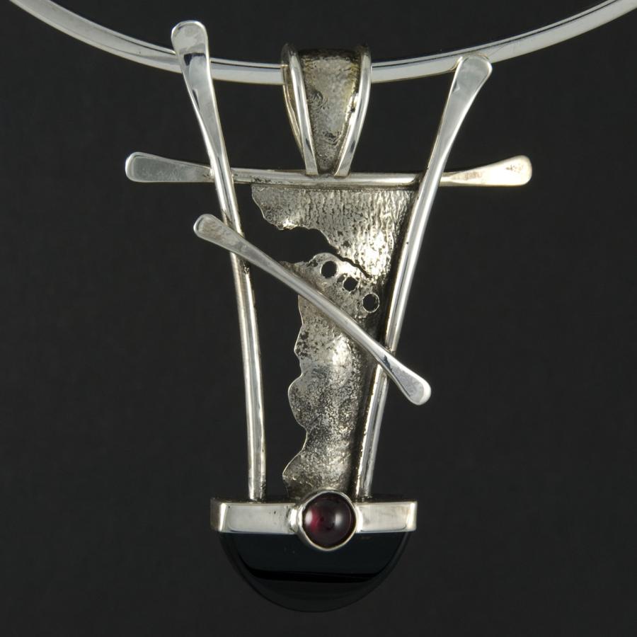 Silver pendant necklace on black background.