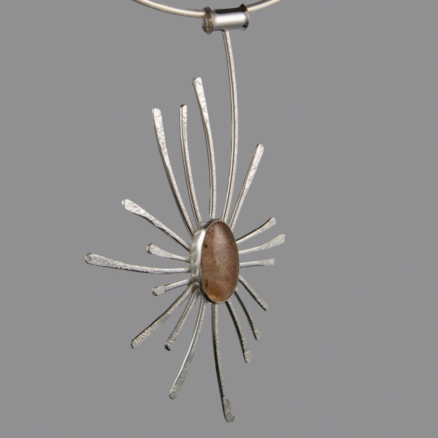 Silver necklace with stone in center.