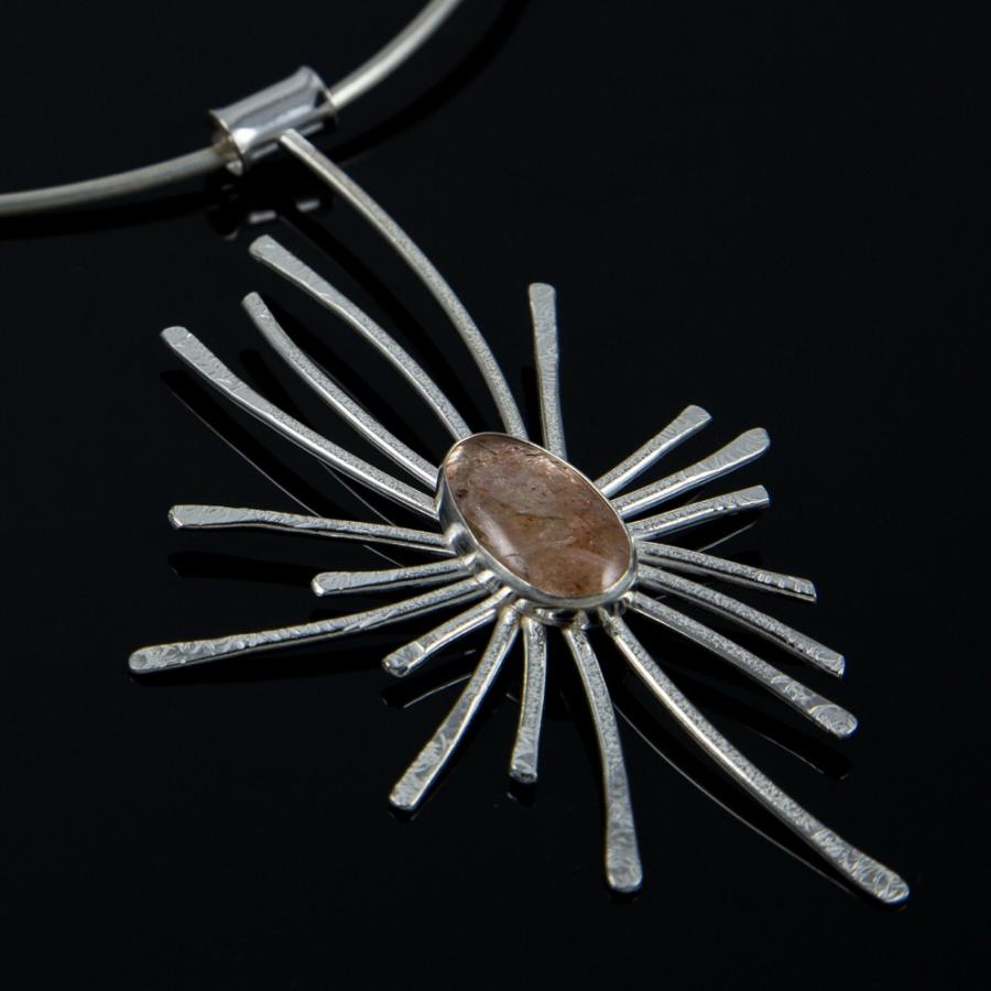 Silver necklace with a sun-shaped pendant.