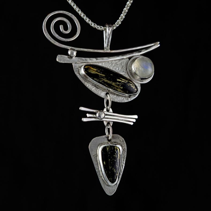 Silver pendant necklace on a black background.