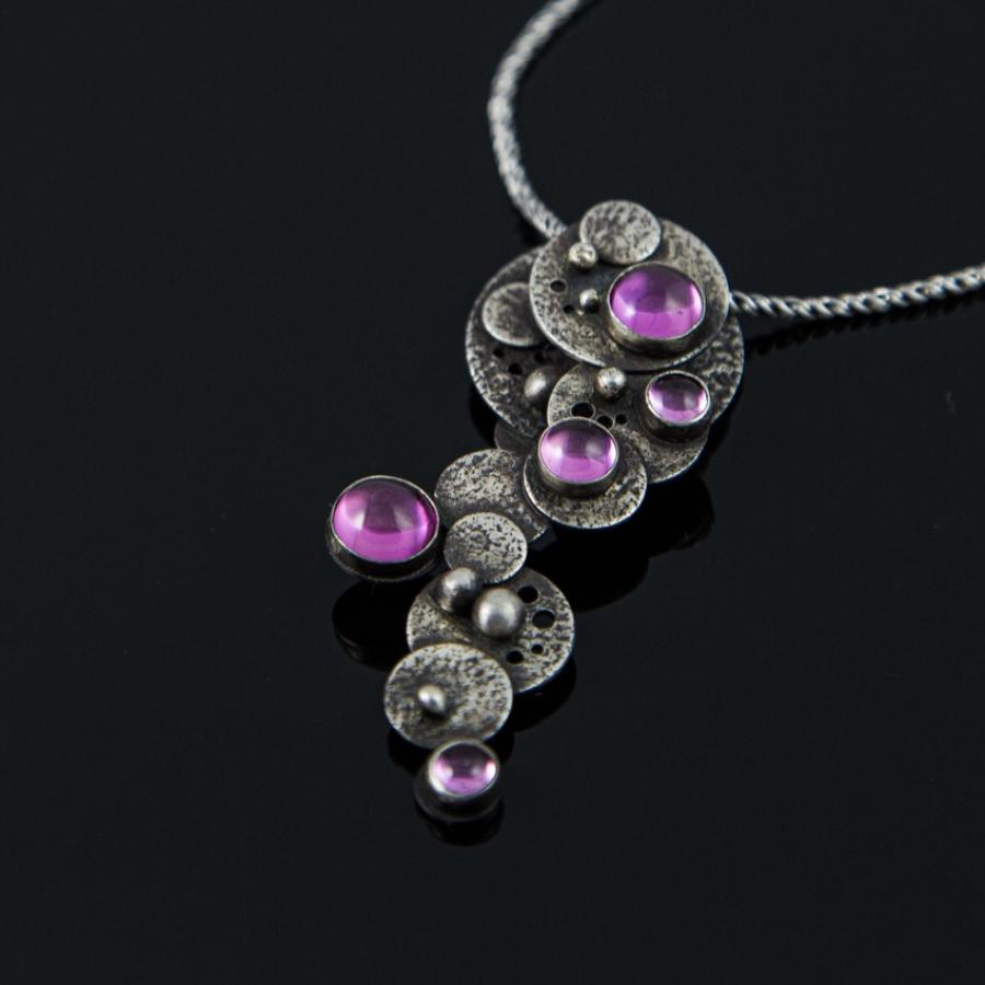 Silver necklace with pink gemstones.