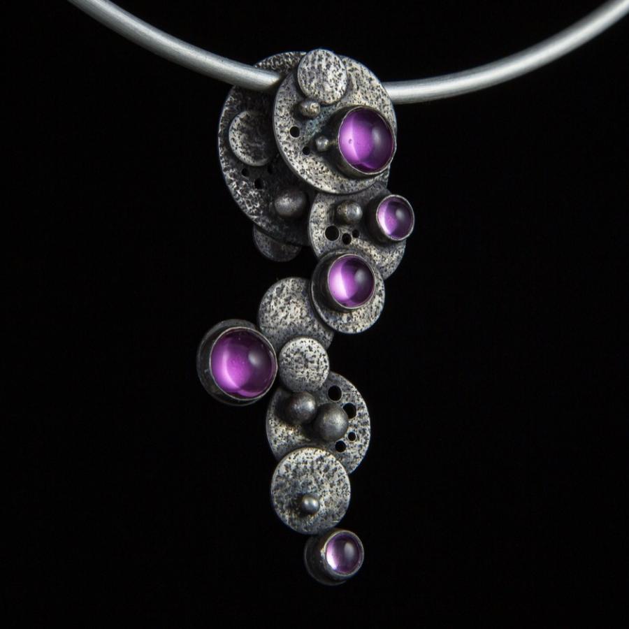 Silver necklace with pink gemstones.