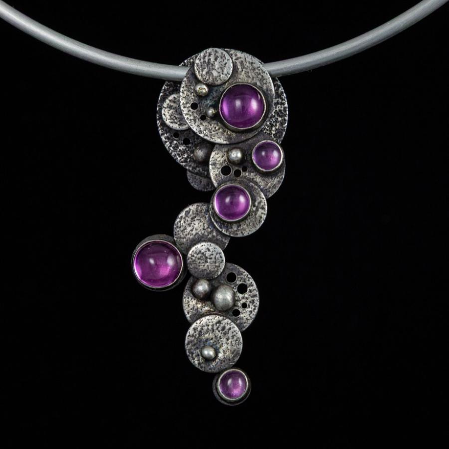 Silver necklace with pink gemstones.