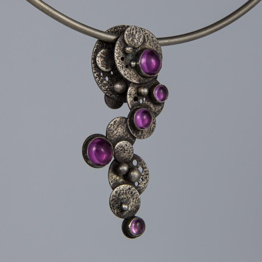 Silver necklace with pink gemstones.