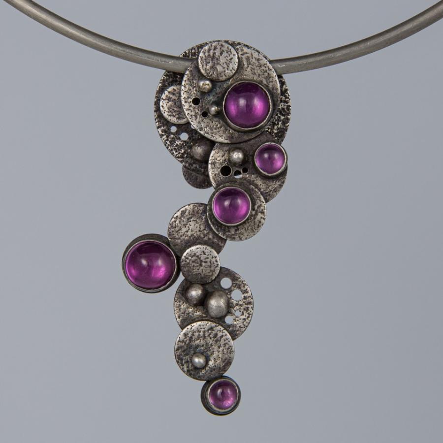Silver necklace with pink gemstones.