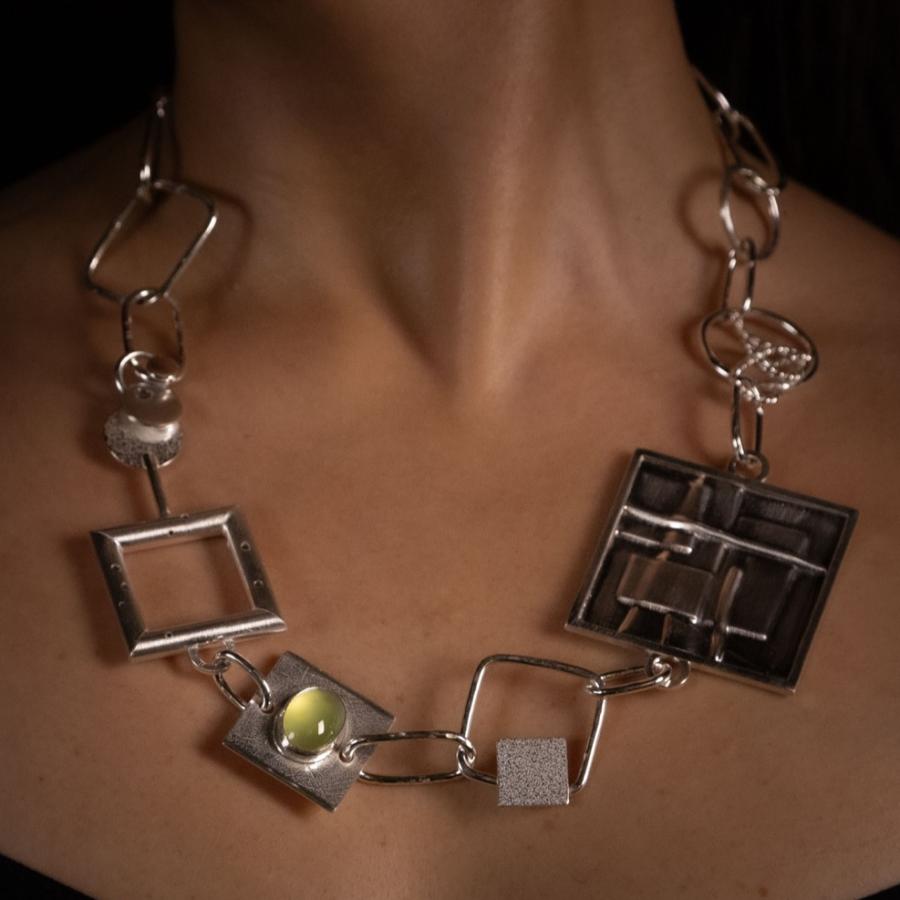 Woman wearing a chunky silver necklace, photograph.