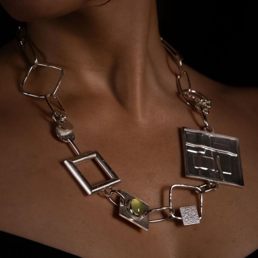 Woman wearing a chunky silver necklace, photograph.