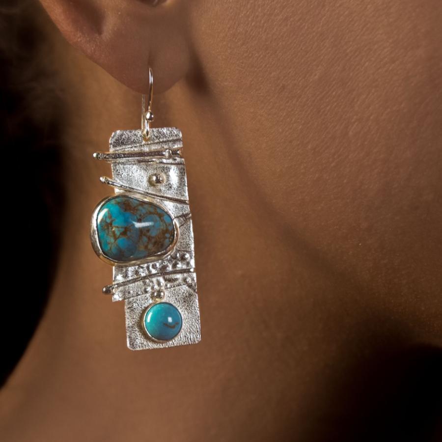 Woman wearing turquoise drop earrings, close-up.