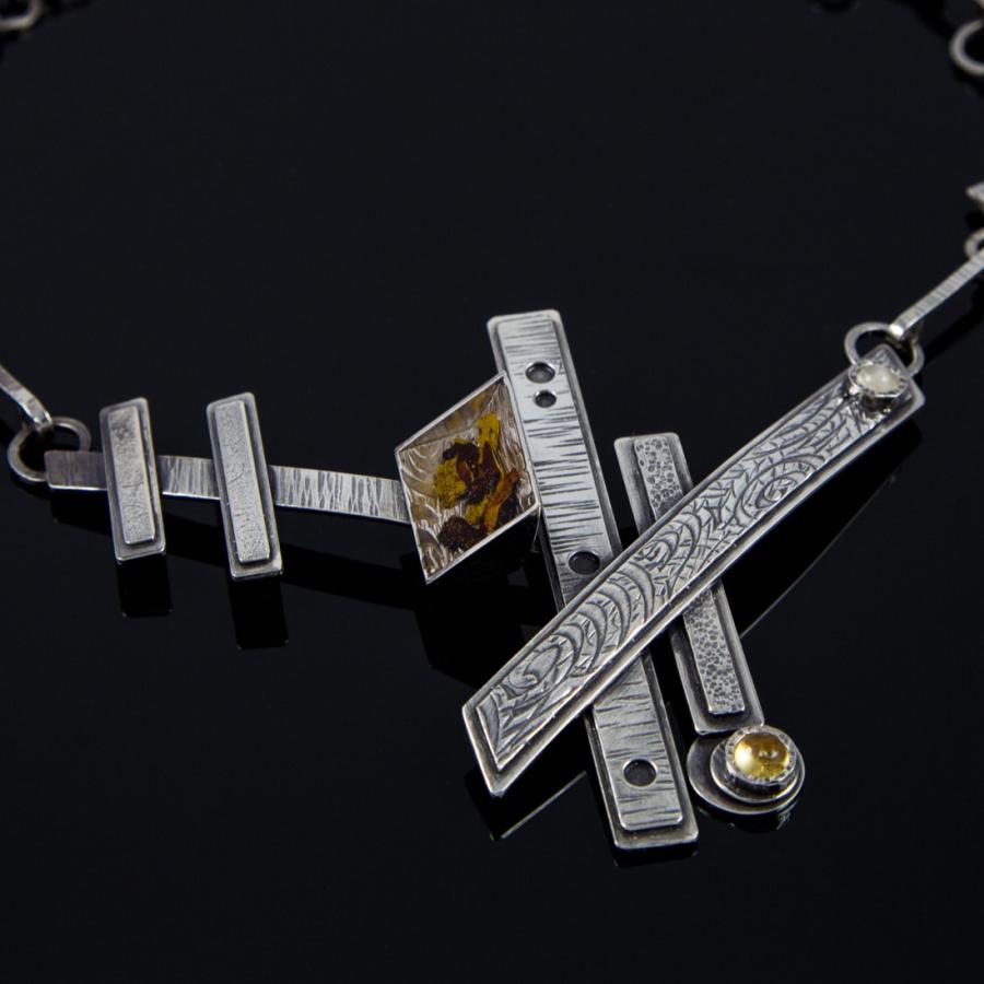 Silver necklace with abstract geometric design.