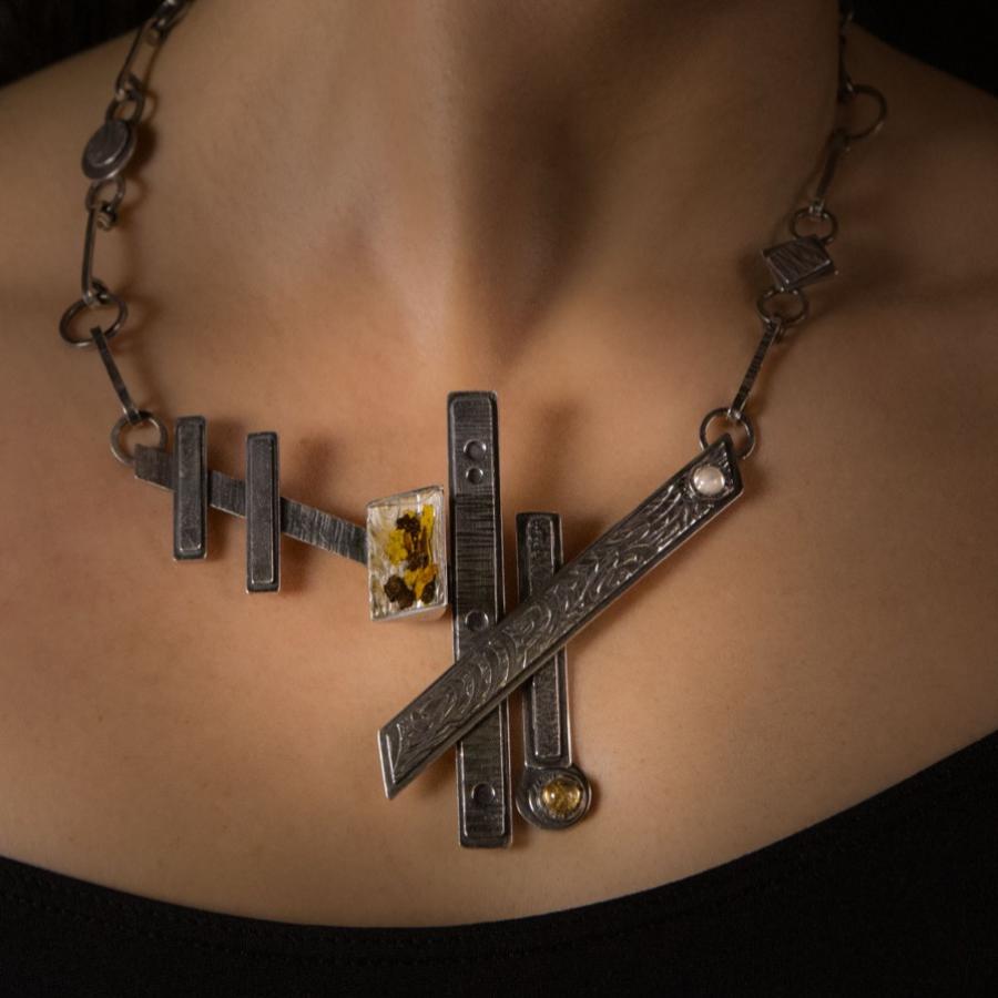 Woman wearing a silver statement necklace.