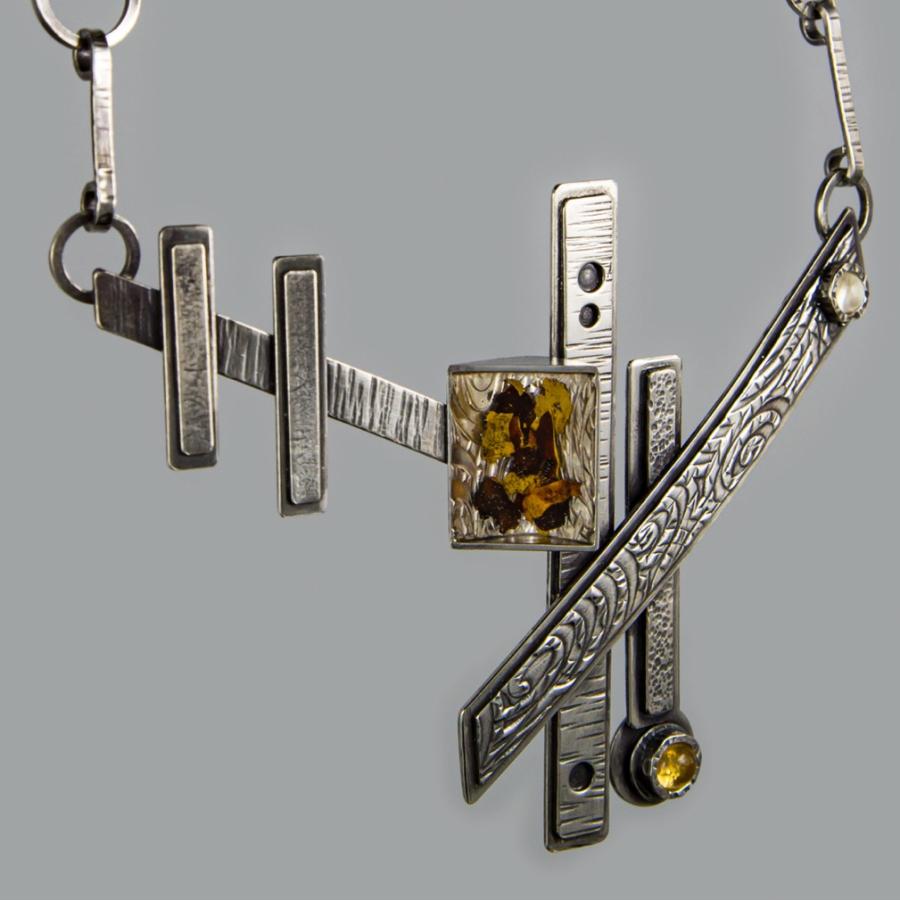 Silver geometric necklace, photograph.