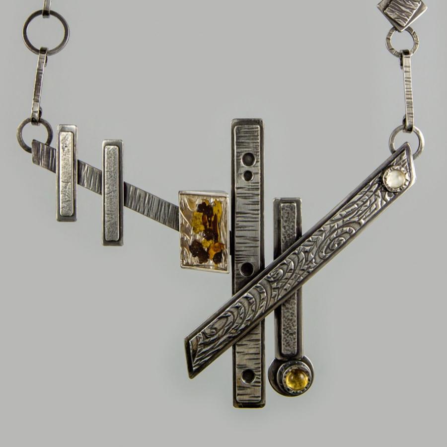 Handmade silver necklace with geometric shapes.