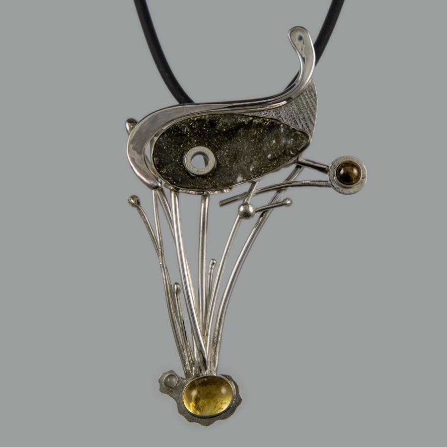 Silver necklace with unique pendant on gray backdrop.