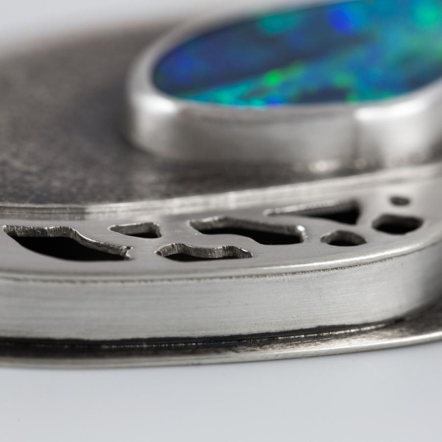 Close-up of a silver pendant with an opal.