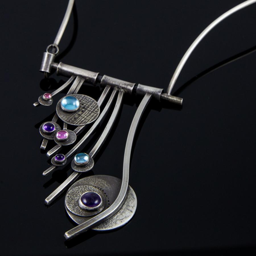 Silver necklace with blue and purple gemstones.