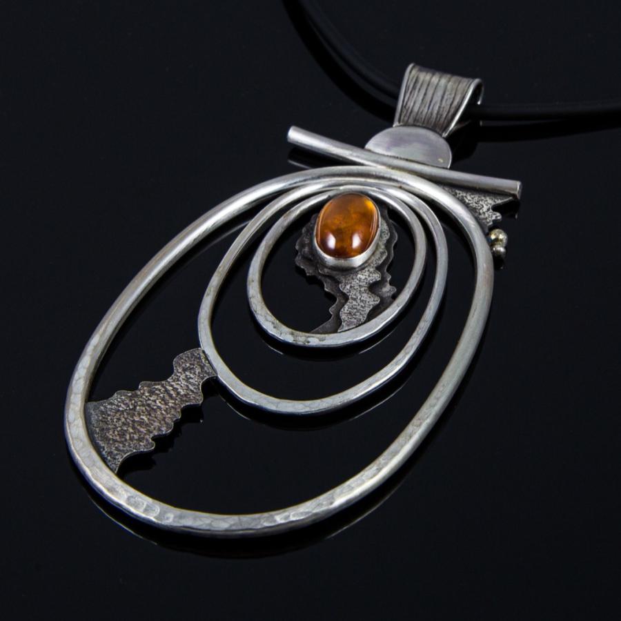 Necklace with silver pendant on black background.