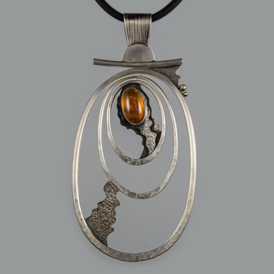 Silver pendant with an orange stone.