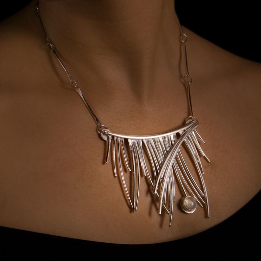 Woman wearing silver fringe necklace, photograph.