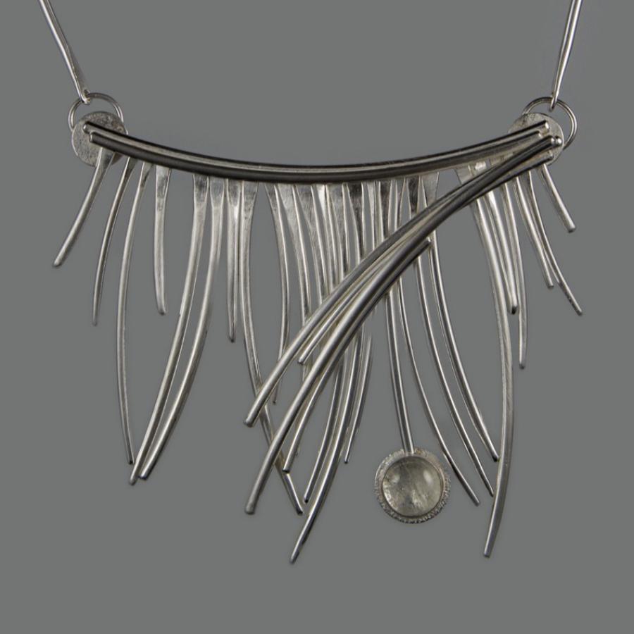 Silver pendant necklace on gray background.