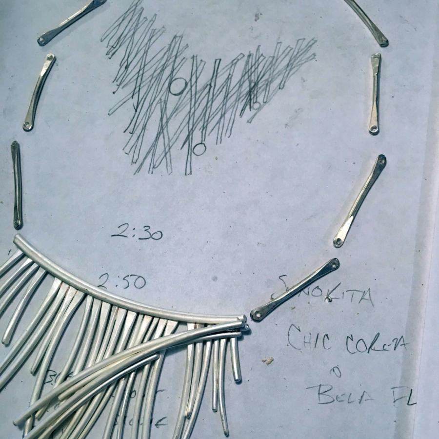 Necklace design sketch with necklace in process.