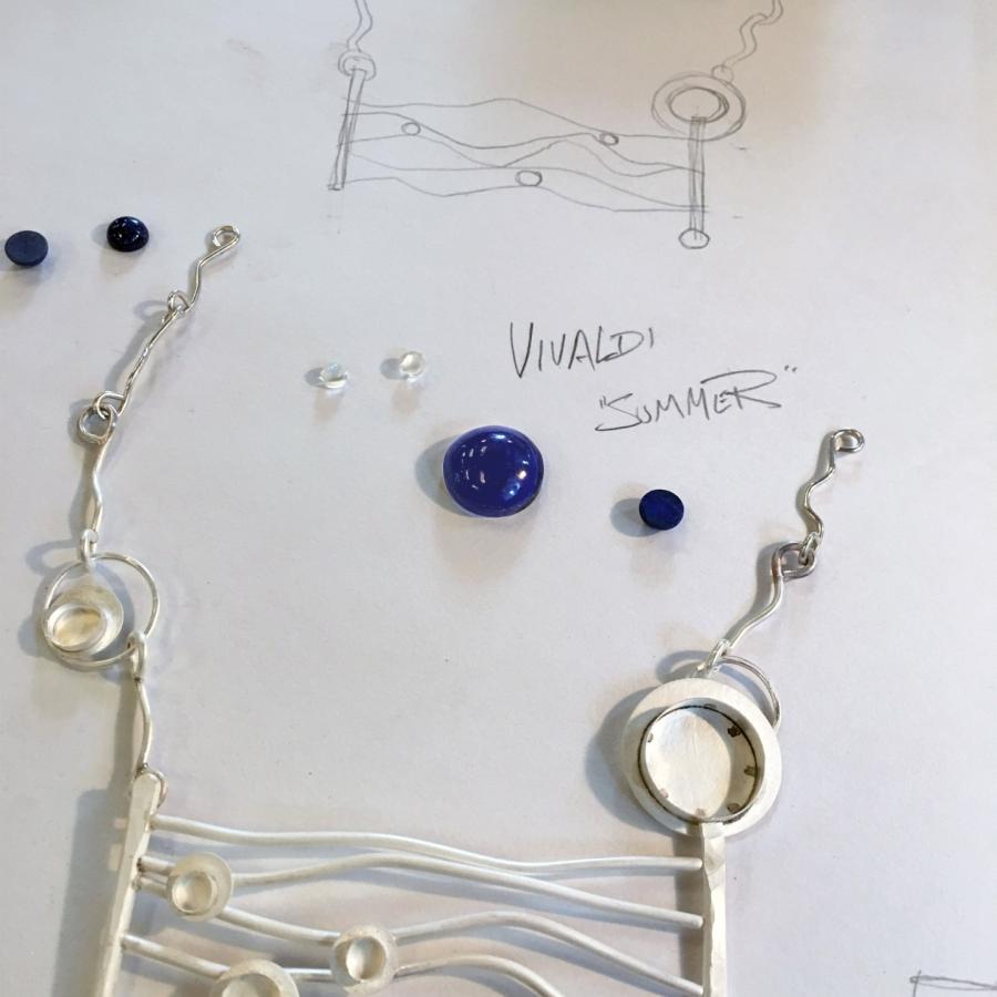 Jewelry design with metal, wire, and blue gems.