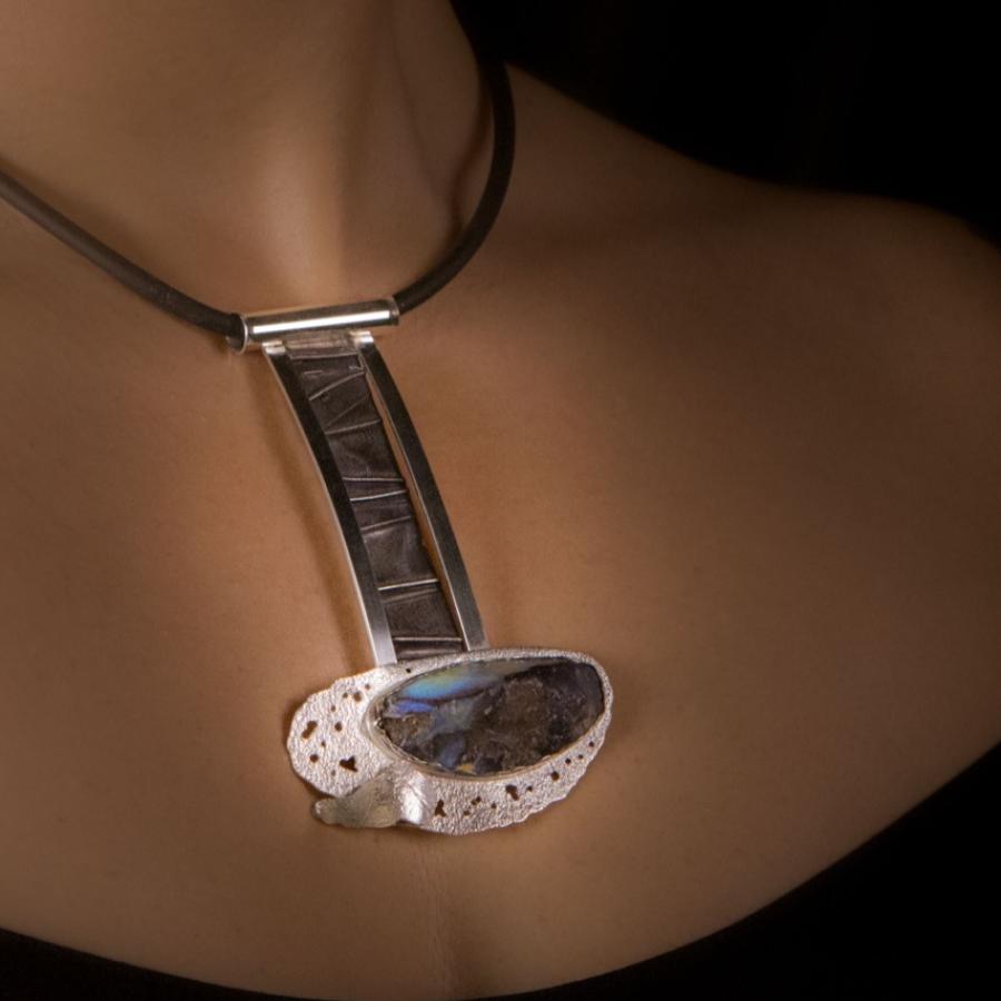 Woman wearing artistic silver pendant necklace.