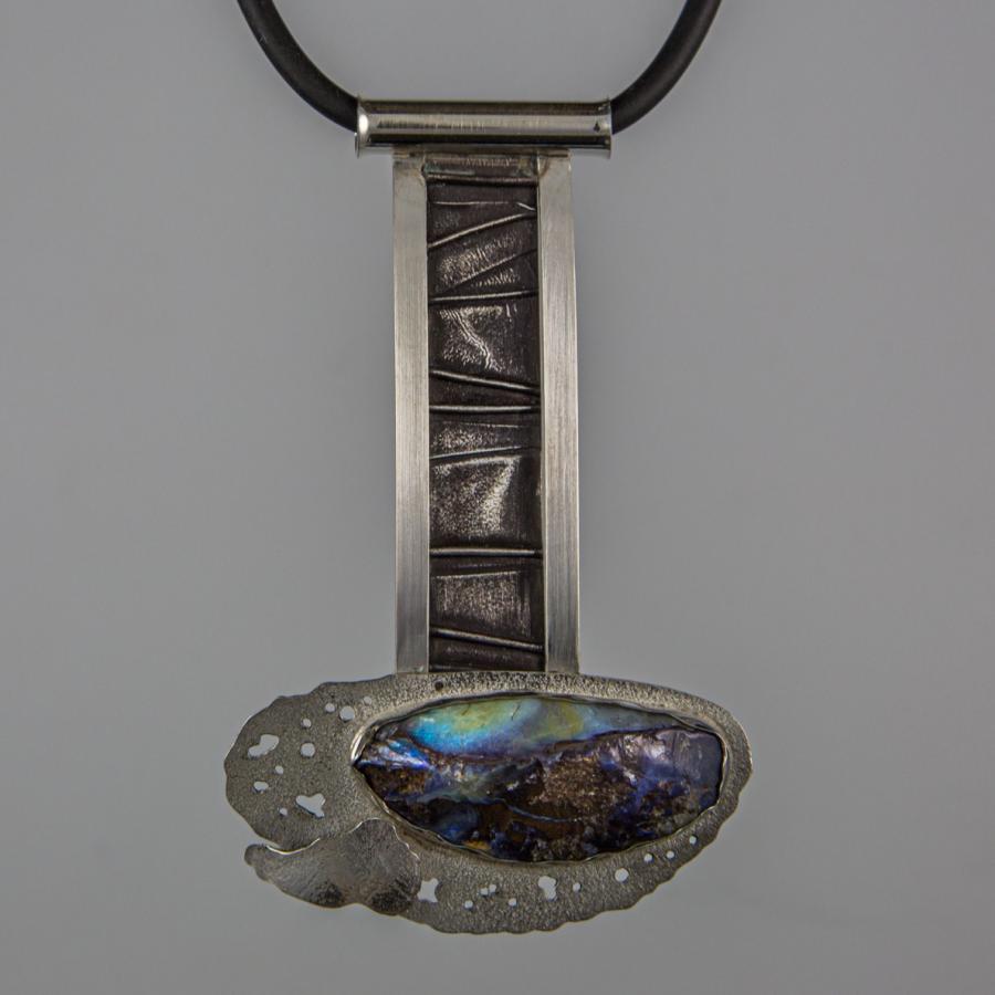 Silver pendant with iridescent stone on black cord.